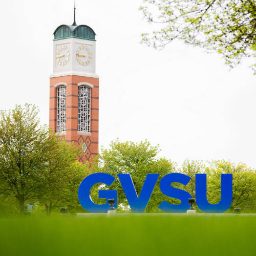 Valley Campus exterior of large GVSU letters in the foreground and clock tower in the background.